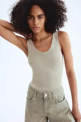 Musculosa de punto fino color gris claro, entallada, con escote en U en la parte delantera y trasera.