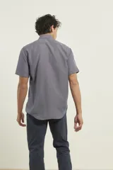 Camisa de manga corta azul con microestampado blanco, cuello abotonado, corte clásico y bolsillo en el pecho.