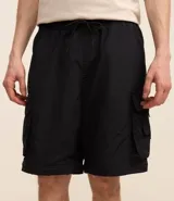 Pantalón paper touch color verde militar, con bolsillos laterales, cintura elástica y cordón de ajuste. Se convierte en bermuda gracias a un cierre a la altura de la rodilla.