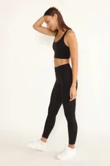 Top deportivo negro con breteles finos cruzados en la espalda y almohadillas removibles.