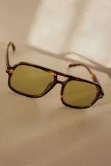 Lentes de sol estilo aviador con armazón carey y lentes grises.