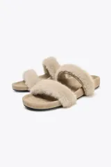 Sandalia plana color beige con dos tiras de pelo sintético y suela de goma.