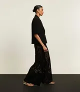 Blazer negro de viscosa con mangas cortas, solapas en el cuello y botón metalizado.