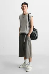 Zapatilla deportiva tipo skate con parte superior fabricada en combinación de piezas y materiales. Detalle de cordones maxi y suela con volumen. Color blanco, gris y crema.