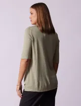 Remera verde con escote redondo y mangas tres cuartos. Presenta bordados en el escote.