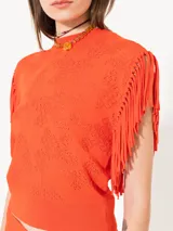 Top color naranja tejido con calados, sin mangas y con flecos en las sisas.