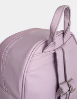 Mochila lila de cuerina con efecto acolchado y colgante de mariposa. Tiene correas regulables, manija superior, acceso con cierre superior y bolsillo frontal con cierre y tirador de goma en forma de mariposa.