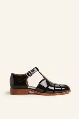 Sandalia de cuero vacuno color negro, con diseño de tiras entrecruzadas y hebilla lateral.