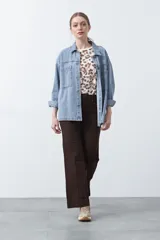 Pantalón negro de tiro alto, corte recto y silueta clásica. Presenta costuras verticales marcadas en la parte delantera de las piernas.