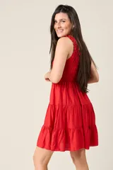 Vestido corto rojo con escote fruncido, tirantes anchos con volantes y cuerpo de nido de abeja. Falda con diseño escalonado.