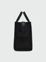 Bolso tote mediano color beige con estampado frontal del logo "The Tote Bag Marc Jacobs" en blanco. Tiene doble asa corta y correa larga extraíble de tela azul marino.