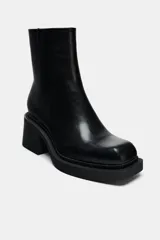 Botín negro de cuero con punta cuadrada, cierre lateral con cremallera y tacón ancho de 6,5 cm.