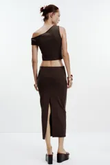 Falda midi color crema, de tiro alto con cintura elástica y detalle de pliegues laterales.
