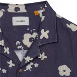 Camisa de manga corta Critical Slide modelo Splatter Resort, color azul oscuro con estampado de flores abstractas en color crema. Presenta cuello tipo resort, calce relajado y cierre frontal con botones.