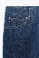 Pantalón de jean celeste de tiro bajo, corte flare, cropped y cinco bolsillos.