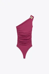 Body fucsia de poliamida con escote asimétrico, un solo tirante con pieza metálica dorada y frunces laterales.