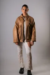 Campera estilo bomber confeccionada en cuero vacuno color marrón claro, de estructura firme y calce holgado.