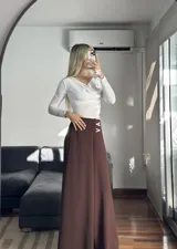 Blusa blanca de poliéster labrado, con cuello drapeado estilo bote y mangas largas.
