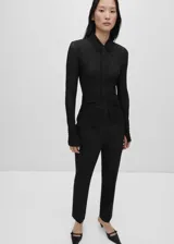 Pantalón de vestir negro de corte recto, con trabillas, bolsillos laterales y cierre oculto de botón, gancho y cremallera.