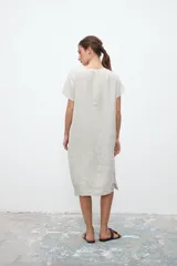 Vestido midi color crudo de lino, corte recto, con cuello en V, mangas cortas y bolsillos laterales.