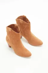 Bota corta de gamuza color camel, estilo cowboy, con taco medio de madera y recortes grabados en forma de mariposa en los laterales.