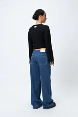 Pantalón de jean gris oscuro, tiro bajo, corte baggy y doble bolsillo.