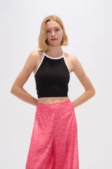 Top blanco de poliamida, corte cropped, al cuerpo y cuello a la base con ribete verde.