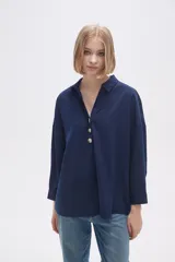 Blusa blanca holgada de poliéster con cuello camisero y mangas largas.
