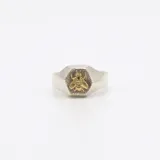 Anillo plateado con forma de sello hexagonal y aplique de abeja dorada en el centro.