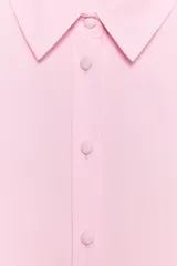 Camisa rosa de cuello solapa y manga larga. Tejido suave. Cierre frontal con botones a tono.