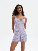 Short de pijama color lila con estampado de flores blancas y ribete de encaje en el ruedo.