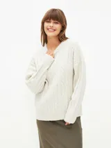 Sweater tejido con trenzas color beige claro, de corte holgado y cuello en V.
