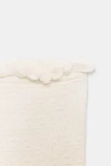 Top corto tipo bandeau de color blanco, con escote recto y hombros descubiertos. Presenta una textura elástica y acabados con bordes ondulados en el escote y el bajo.