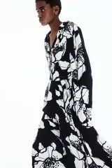 Vestido camisero midi de viscosa con estampado floral en blanco y negro, cuello camisero, tapeta de botones oculta, mangas raglán largas con puños sencillos y costuras fruncidas en la pollera.