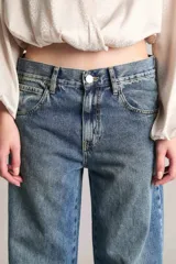 Pantalón de jean de tiro medio, corte wide leg extra largo, color azul medio.