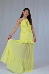 Conjunto de top y falda larga color amarillo, con breteles finos, detalle de encaje en el top y volados en top y falda.