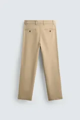 Pantalón chino color beige, de corte recto y tiro medio. Confeccionado en tejido de algodón con elasticidad, con bolsillos laterales y traseros de vivo. Cierre frontal con cremallera y botón.