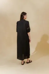 Vestido midi negro de lino, corte recto, con escote en V con volados y mangas 3/4 con puntillas.