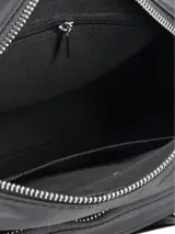 Cartera tipo bandolera o 'camera bag' de nylon negro, con múltiples compartimentos frontales con cierre de cremallera. Presenta un logo metálico plateado en el frente y correa ajustable con diseño de rayas blancas y grises.