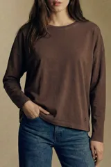 Remera oversize de manga larga color marrón, con cuello redondo y efecto de lavado. Presenta un pequeño bordado en forma de estrella en la parte inferior.