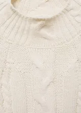 Sweater color crema de punto trenzado, con cuello Perkins y mangas largas con puños elásticos.
