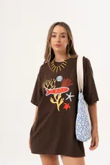 Remerón oversize de algodón color chocolate con estampado de motivos marinos en tonos rojo, amarillo, azul y blanco.