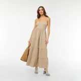 Vestido largo color beige con tirantes finos, corte imperio y falda con capas.
