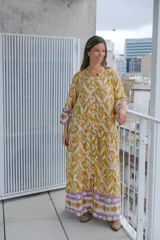 Vestido largo color mostaza con estampado abstracto en blanco, corte holgado, cuello mao y mangas largas con puños elastizados.