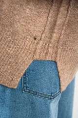 Sweater color marrón claro de tejido de punto, con cuello redondo y mangas largas.