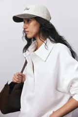 Gorra de béisbol color crema con visera marrón y bordado frontal con la leyenda "Tribeca Tennis Club".