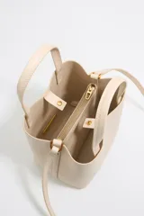 Bolso tote pequeño de cuero sintético color negro con doble asa de mano y correa bandolera ajustable y extraíble. Logotipo de la marca en letras doradas en la parte frontal.