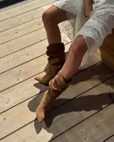 Botines dorados de cuero vacuno con punta fina y tacón aguja.