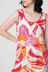 Vestido corto sin mangas con estampado de hojas en tonos rosa, naranja y blanco.