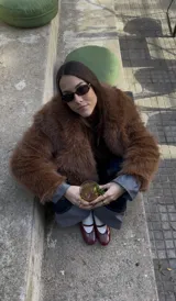 Campera de pelo sintético color beige, con cuello solapa, cierre con botones y bolsillos laterales.